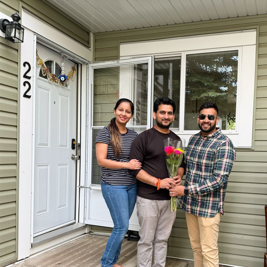 Satyam Tejpal handing flowers to a couple at their new front door